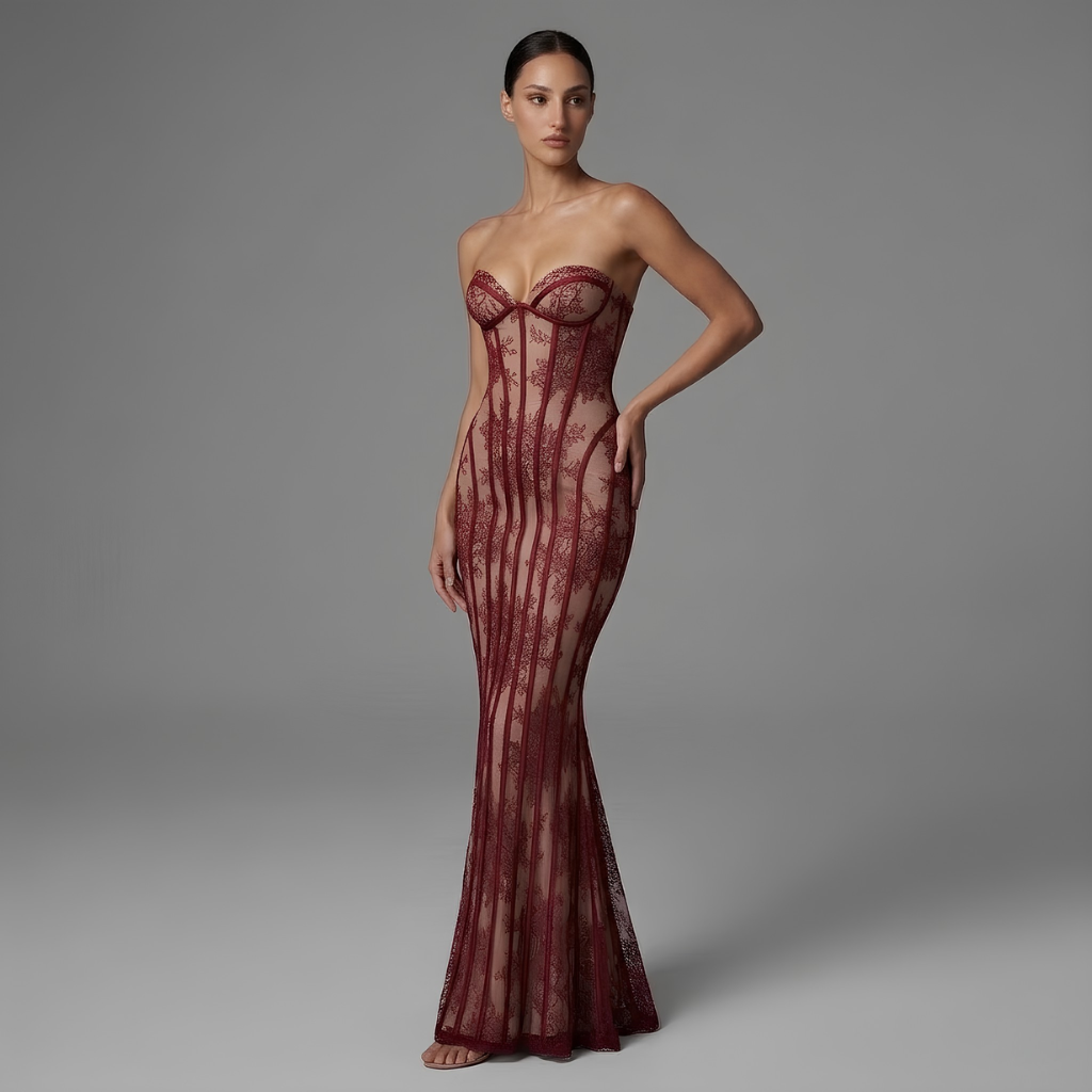 Model wearing a burgundy lace evening gown against a gray background