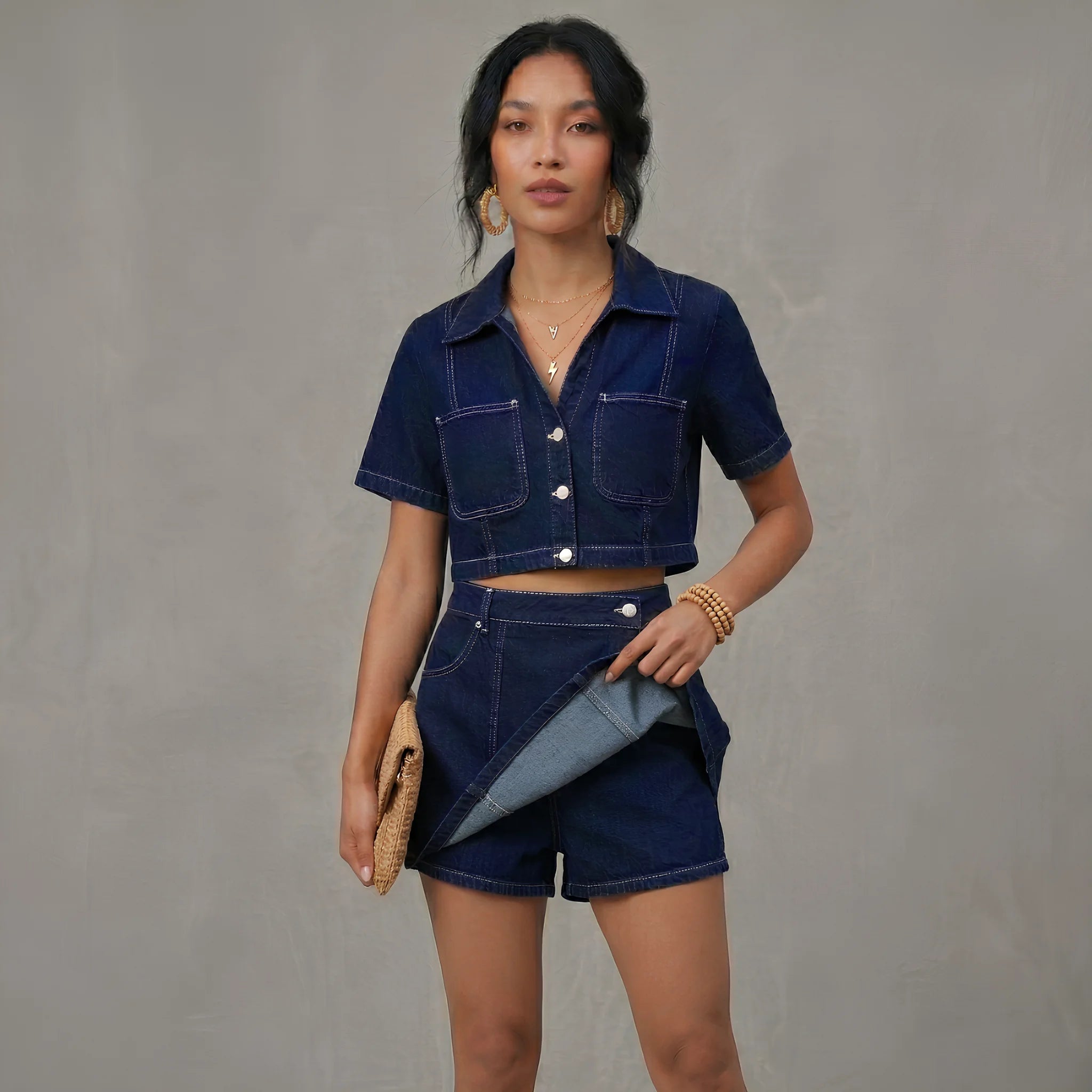 Woman wearing a denim outfit against a gray background
