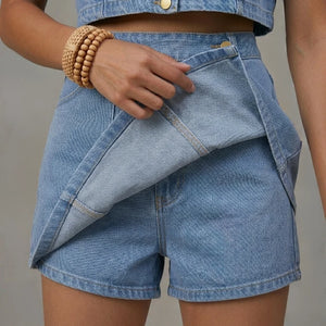 Person wearing a denim outfit with shorts and a jacket on a neutral background