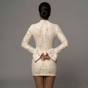 Woman wearing a white lace dress against a gray background
