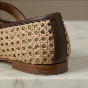 Pair of woven shoes with brown straps on a marble surface