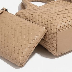 Beige woven handbag on a white background