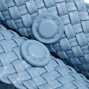 Close-up of blue woven sandals with button details
