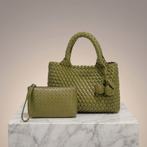 Green woven handbag and matching pouch on a marble surface with a neutral background