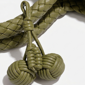 Close-up of braided green leather shoelace on a white background