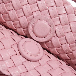 Close-up of pink woven shoes with button details