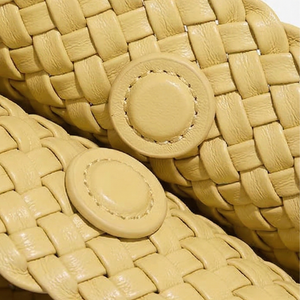 Close-up of beige woven sandals with round straps.