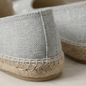 Close-up of gray espadrille shoes with jute sole on a light background