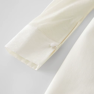 Close-up of a white fabric with a button on a light gray background