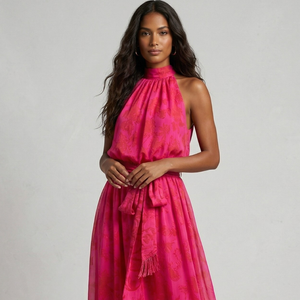Woman wearing a pink dress with a matching shawl against a gray background