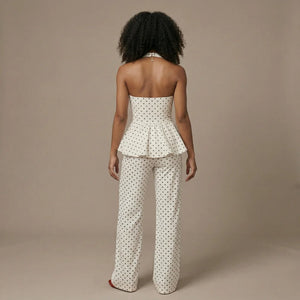 Woman wearing a polka dot strapless top and pants on a beige background