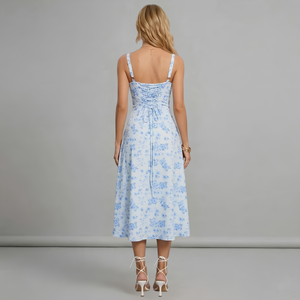 Woman wearing a light blue floral dress against a gray background