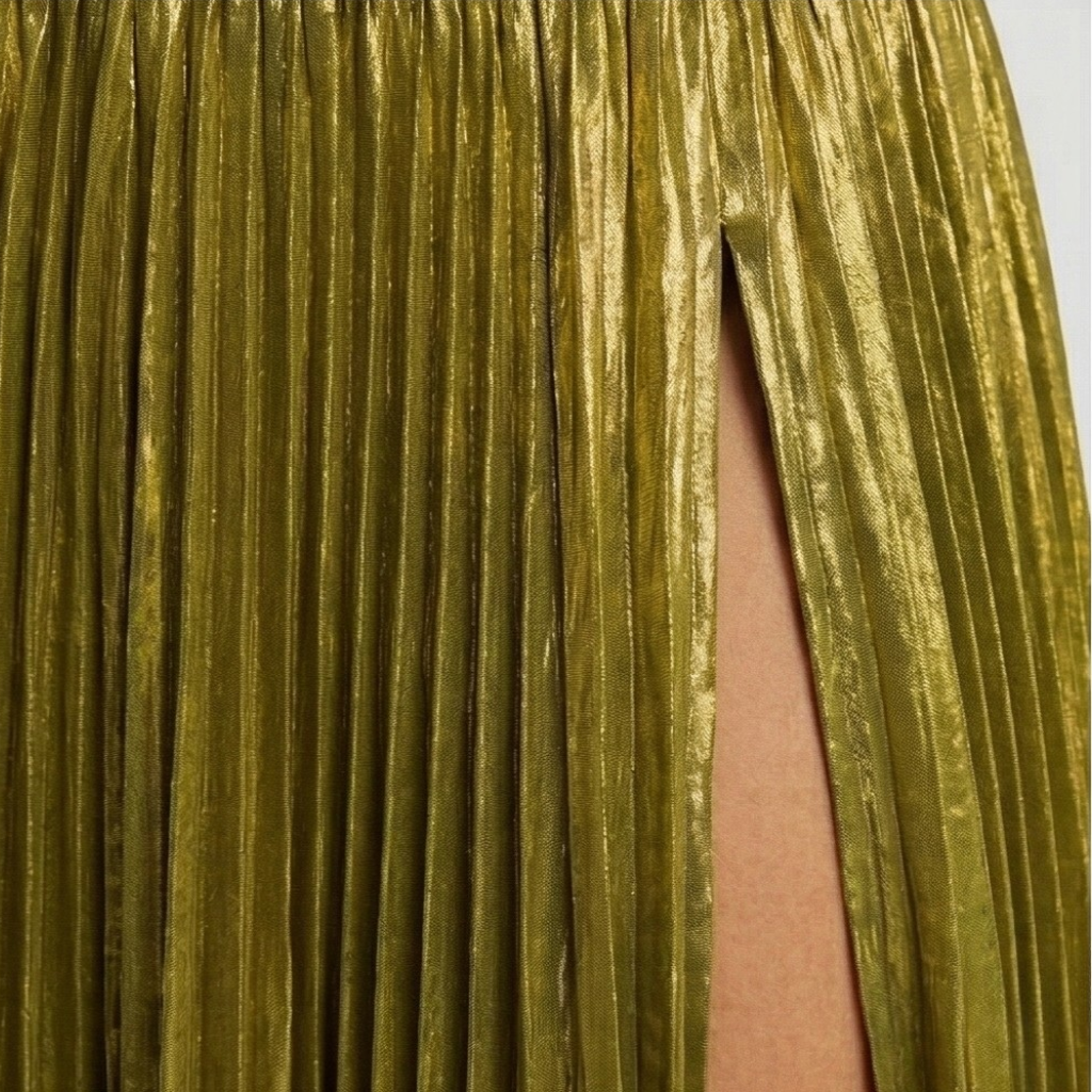 Close-up of a gold pleated skirt with a plain background