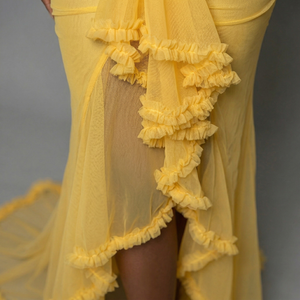 Yellow dress with ruffled details on a gray background