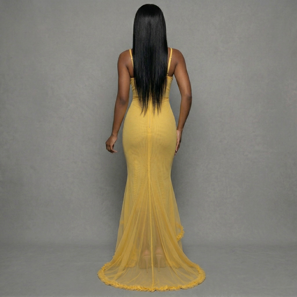Woman wearing a yellow evening gown against a gray background