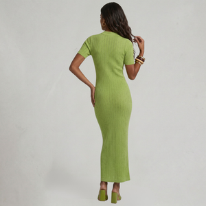 Woman wearing a green dress against a gray background