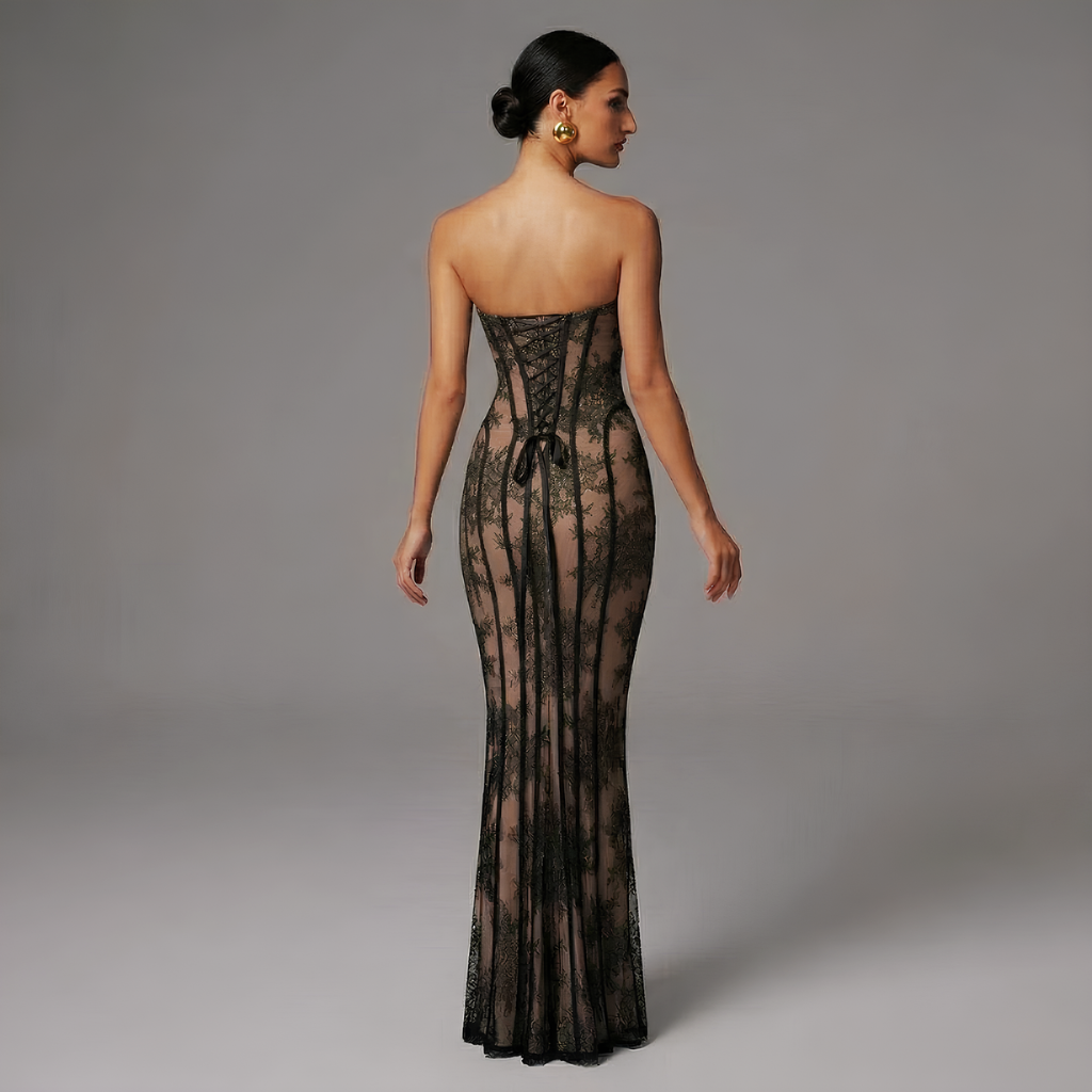 Woman wearing a black lace strapless gown against a gray background