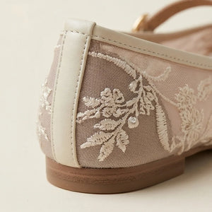 Close-up of a shoe with floral embroidery on a light background