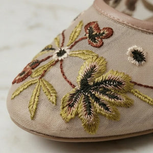 Embroidered shoe with floral design on a beige background
