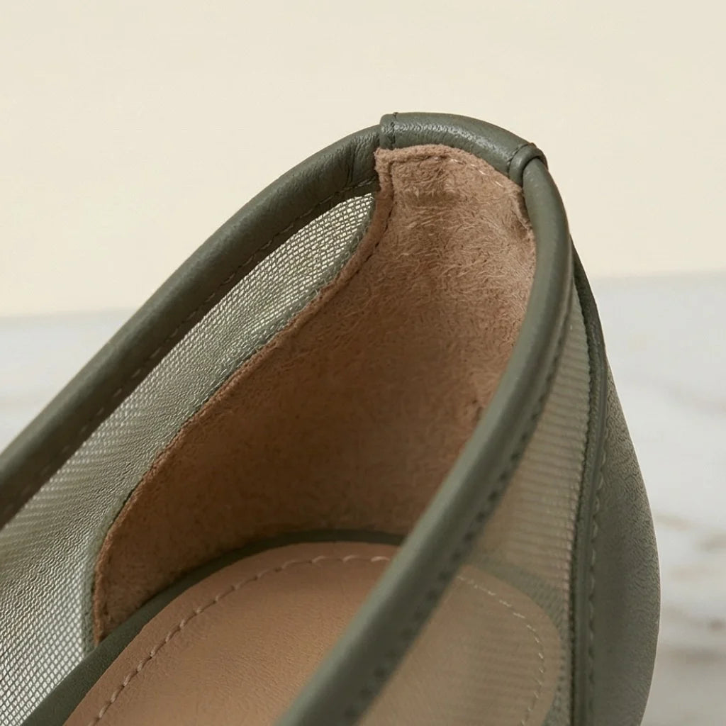 Close-up of a green shoe with brown lining on a light background