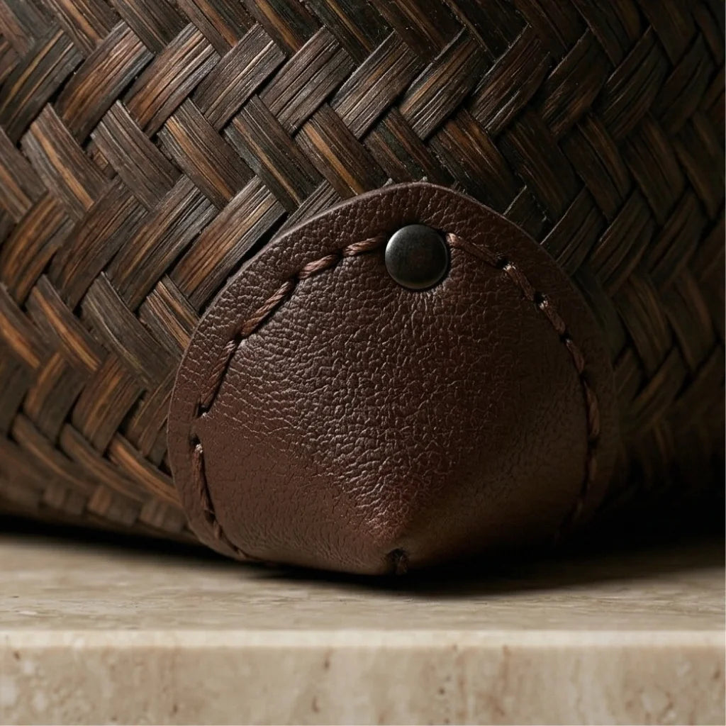 Close-up of a brown woven basket with a leather tag on a wooden surface.