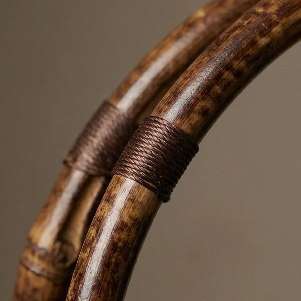 Close-up of two wooden sticks with woven brown string on a brown background