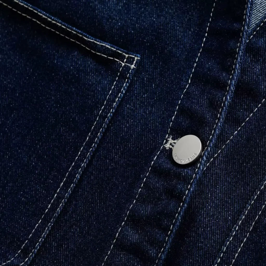 Close-up of a blue denim jacket with a brand logo on a button.