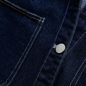 Close-up of a blue denim jacket with a brand logo on a button.