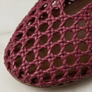Close-up of a pink woven shoe on a light background
