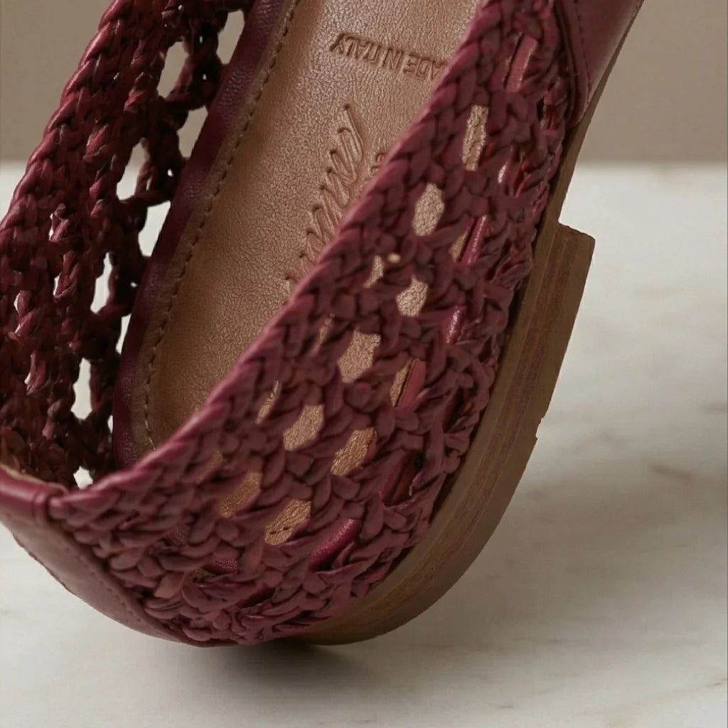 Close-up of a maroon sandal with wooden sole on a light background