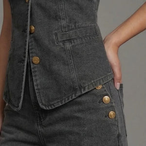 Dark denim vest with gold buttons on a neutral background