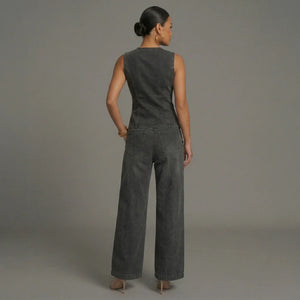 Woman wearing a gray sleeveless top and wide-leg pants against a plain background