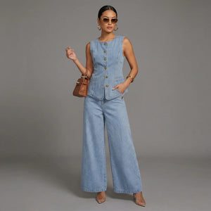 Woman wearing a denim vest and wide-leg jeans on a gray background