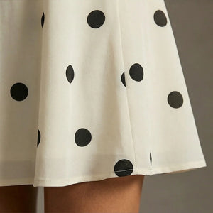White skirt with black polka dots on a neutral background