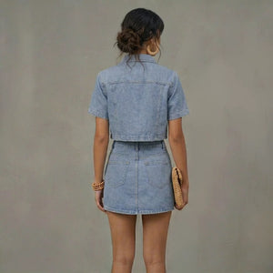 Woman wearing a denim outfit against a plain background