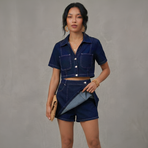 Woman wearing a denim outfit against a gray background