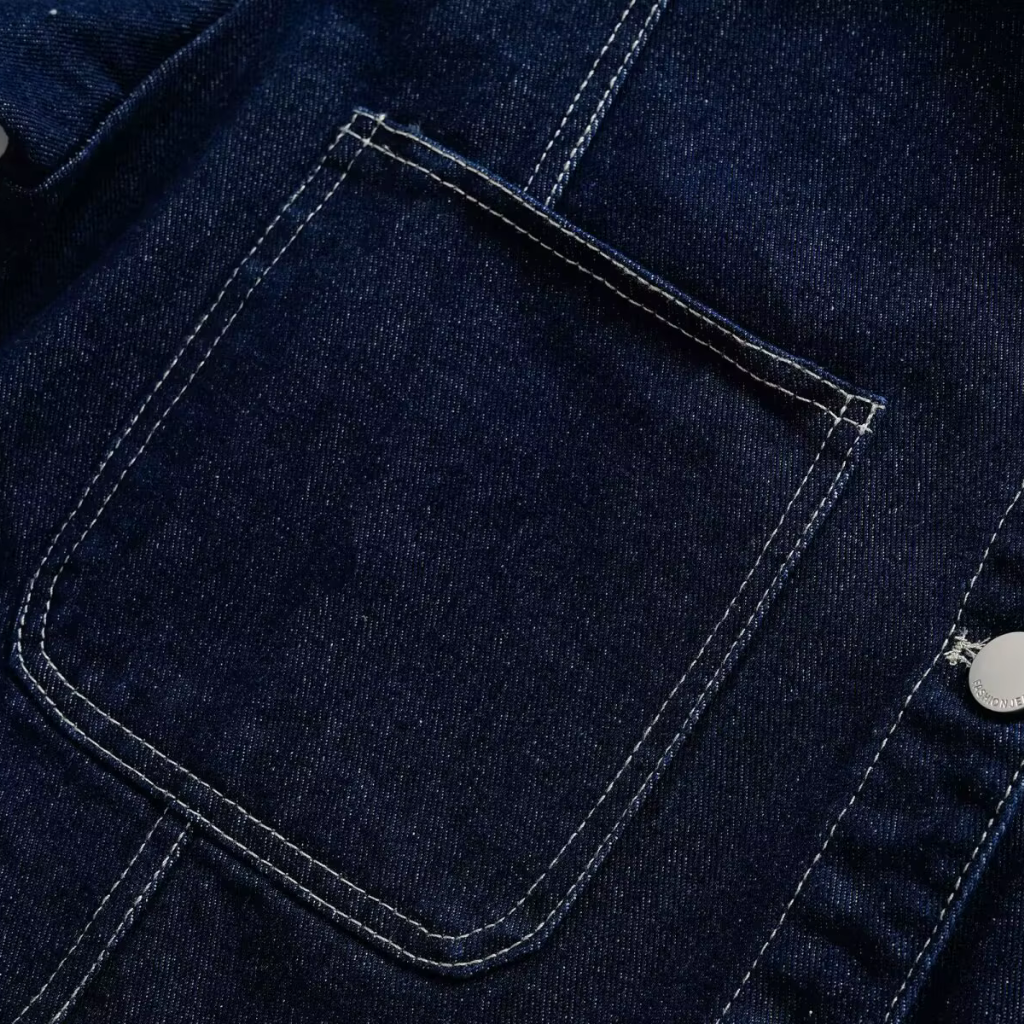 Close-up of a dark blue denim pocket with stitching details.