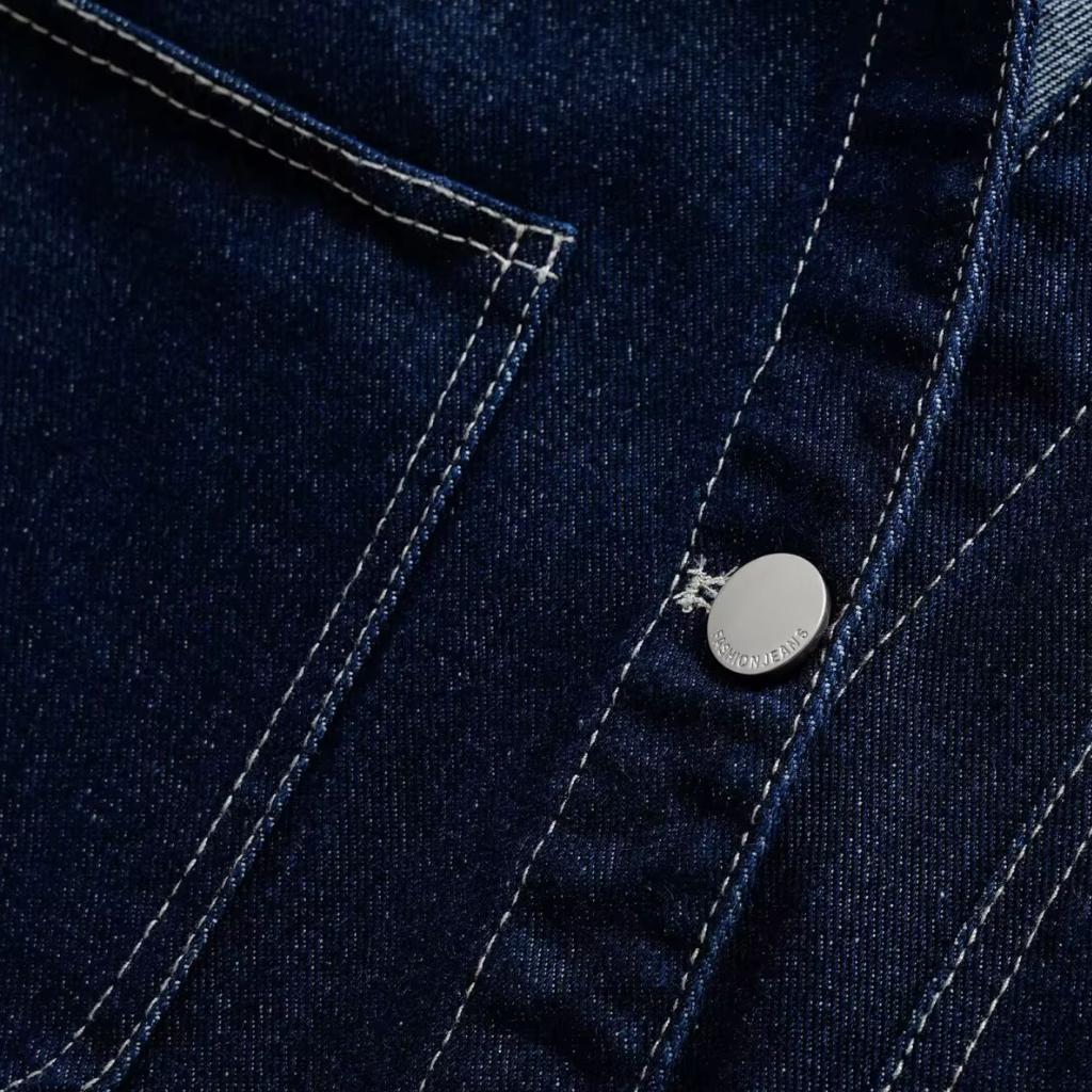 Close-up of a blue denim jacket with a brand logo on a button.