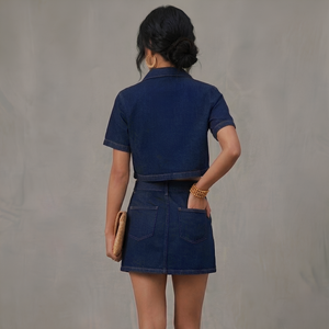 Person wearing a blue denim outfit against a gray background