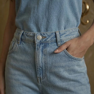 Light blue denim jeans with a button and zipper detail.
