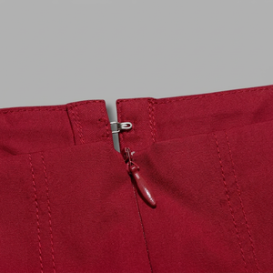 Close-up of a red zipper on a gray background