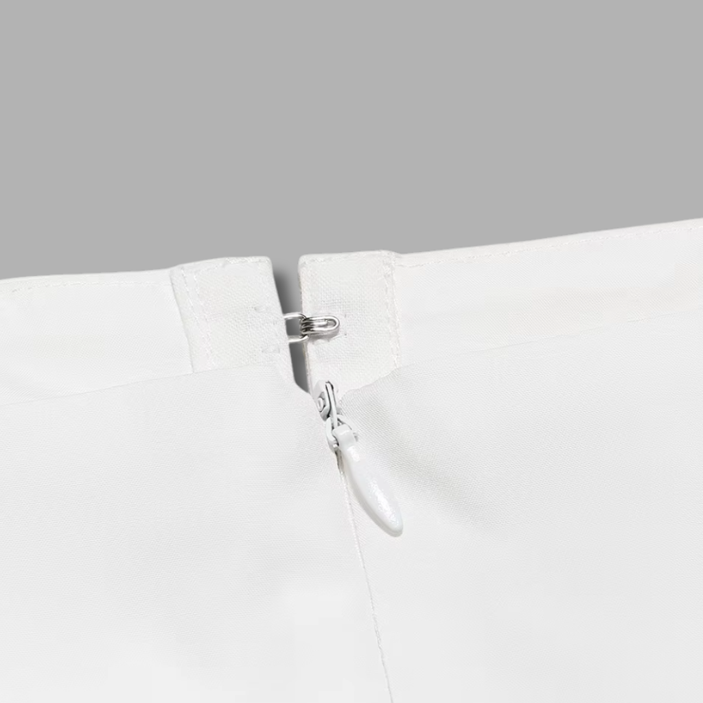 Close-up of a white garment with a silver zipper on a gray background