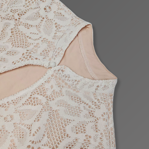 Close-up of a beige lace top on a gray background