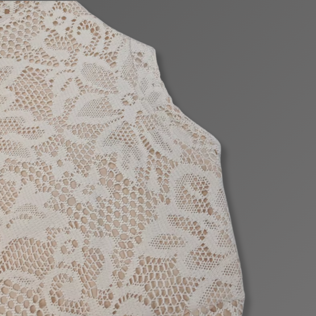 Close-up of beige lace fabric on a gray background