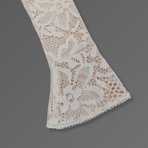 Close-up of a lace fabric strip on a gray background