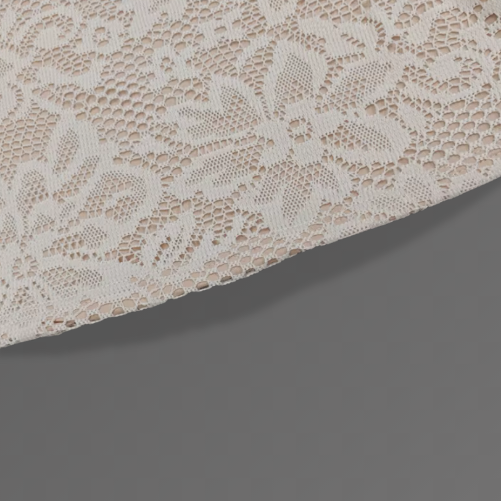 Close-up of beige lace fabric on a dark gray background