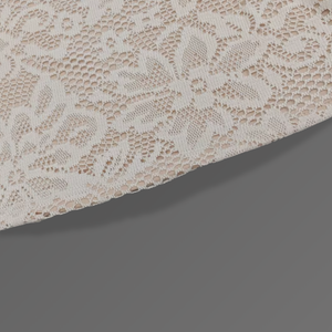 Close-up of beige lace fabric on a dark gray background