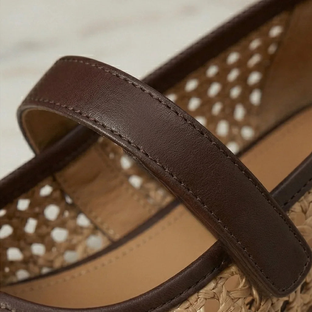 Close-up of a sandal with a brown strap on a beige background