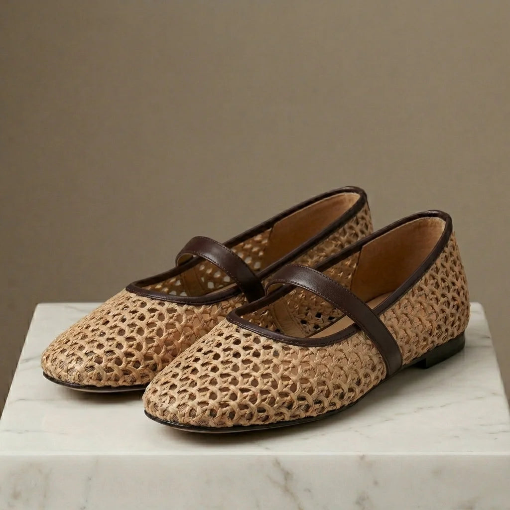 Pair of woven shoes with brown straps on a marble surface against a beige background