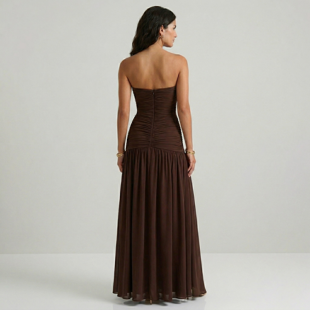Woman wearing a brown strapless gown on a plain background
